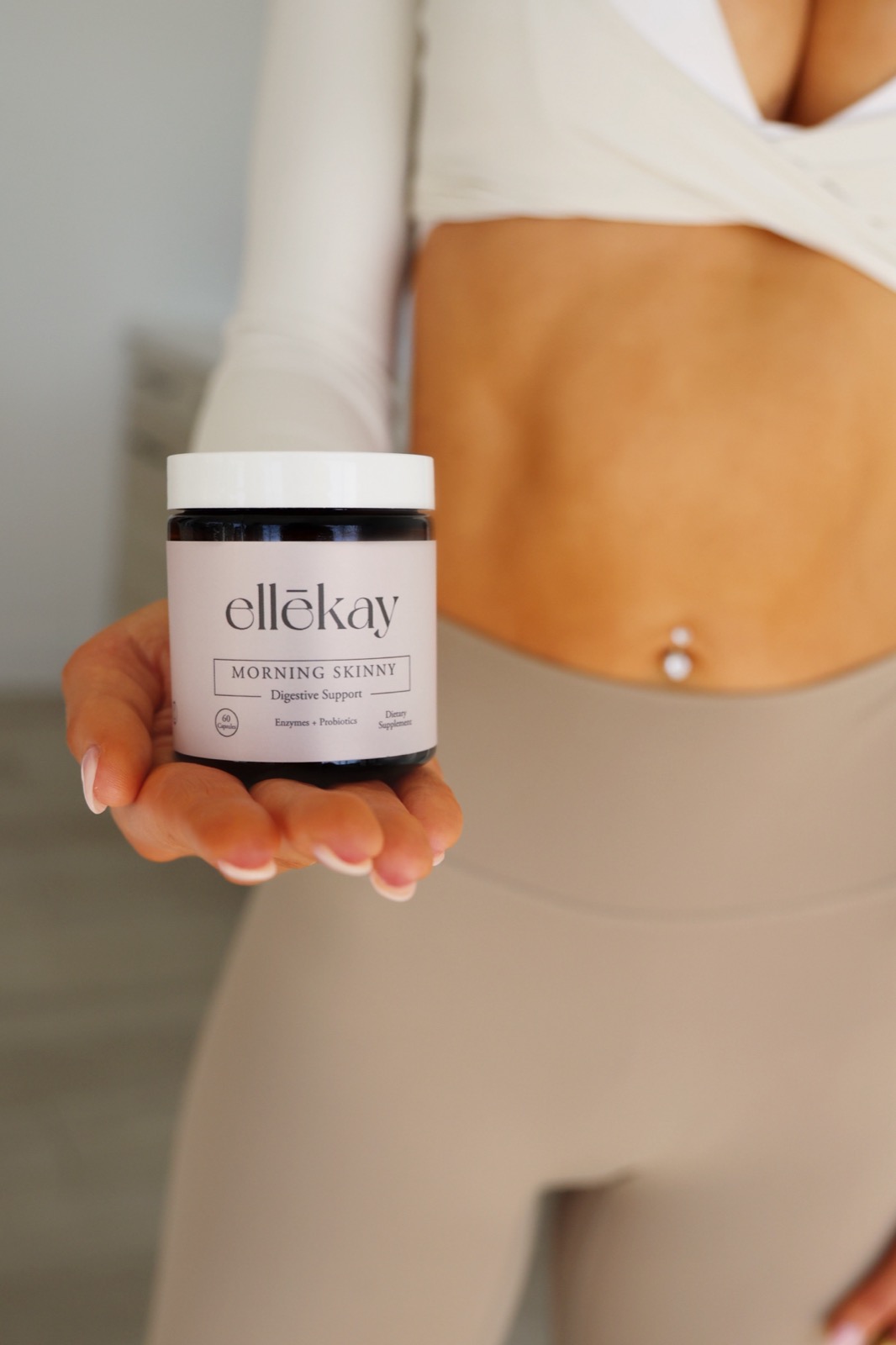 Lauren, founder of ellēkay, holding out a jar of Morning Skinny