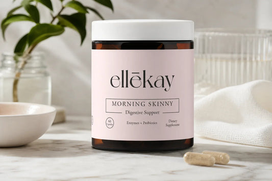 Woman placing a digestive enzyme supplement capsule beside a glass of water at a bright morning kitchen counter