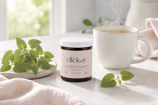 Lemon balm supplement bottle and fresh lemon balm leaves on a kitchen counter for a gut health wellness routine