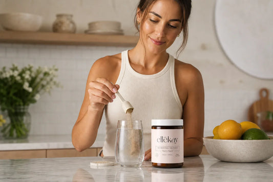 Woman preparing a gut health wellness drink at a bright sunlit morning kitchen counter, representing mucin layer and gut health
